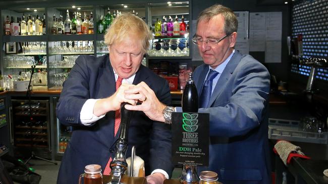 British Prime Minister Boris Johnson pulls a pint at Sedgefield Cricket Club in County Durham on Saturday.