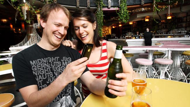 Chris Milne and Darcy Laughlin try out a new iPhone beer app at Brisbane's Cloudland Bar. Picture: Lyndon Mechielsen