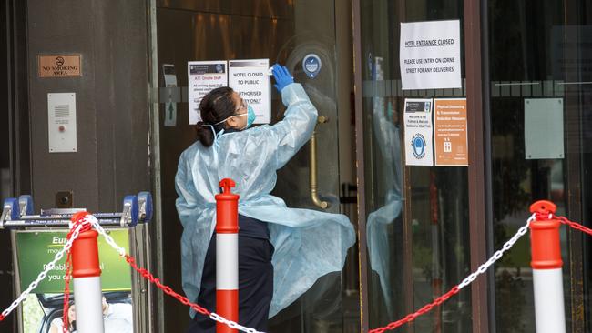 A worker cleans a door at the Pullman Albert Park Hotel. Picture: NCA NewsWire/David Geraghty