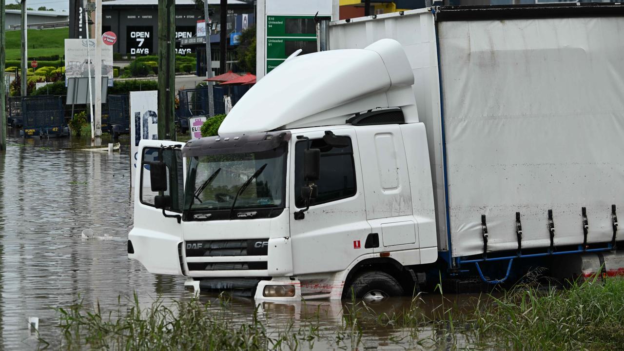 Partly submerged trucks in floods near the Puma service station in Strathpine after flooding rains fell in the area Picture: Lyndon Mechielsen