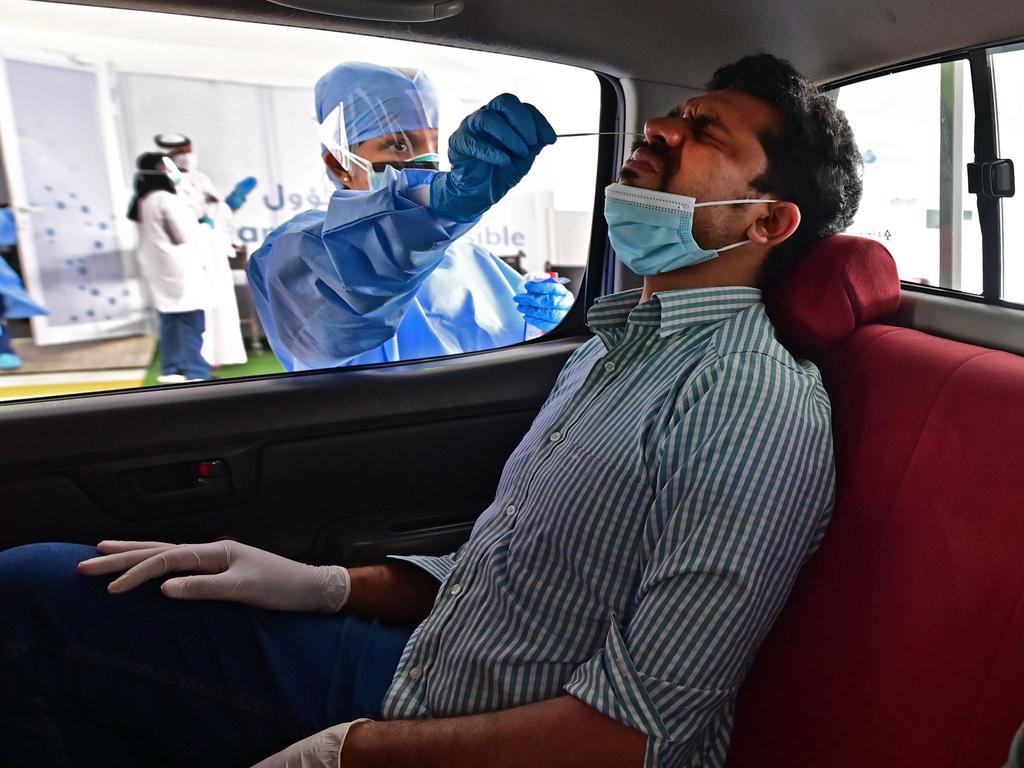 A nurse administers a coronavirus test on the passenger of a car at a drive through verification centre in Abu Dhabi on Thursday. Picture: Giuseppe Cacace/AFP