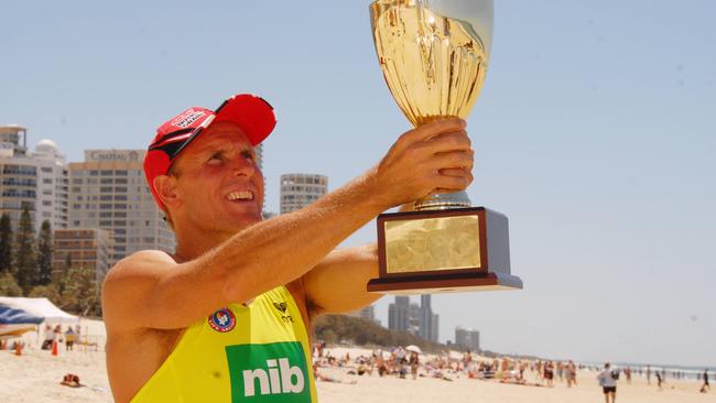 Ironman Dean Mercer holds the Coolangatta Gold trophy.