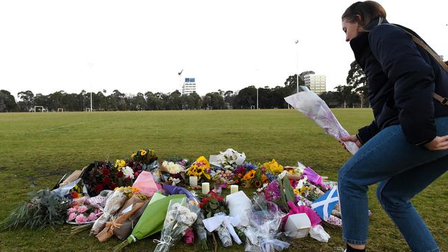 A mourner leaves flowers at Princes Hill. Picture: Nicole Garmston