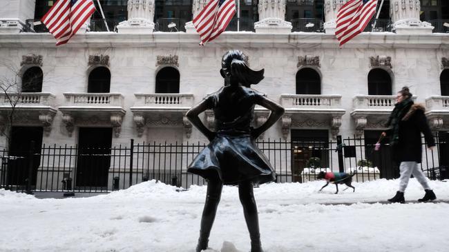 People walk by the Fearless Girl statue outside the New York Stock Exchange. Picture: AFP