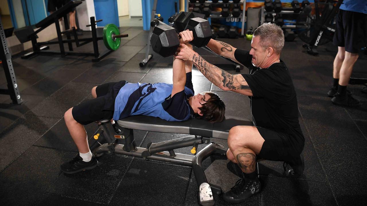 Mr Stensholm helps a young man workout after school. Picture: Patrick Woods.