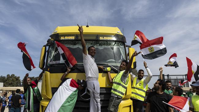 Volunteers and NGOs staff celebrate after unloading aid supplies and returning to Egyptian side of border. Picture: Getty