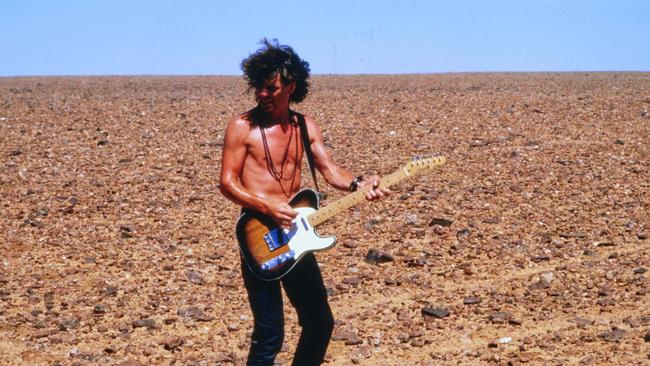 INXS guitarist Tim Farriss under the blazing outback sun on the Kiss The Dirt video shoot. Picture: Supplied.