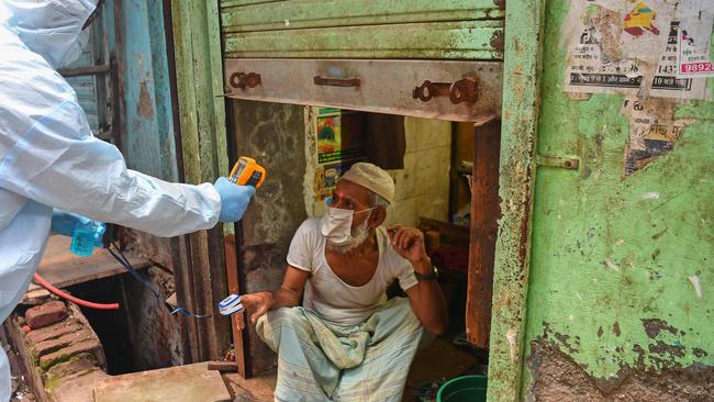 Medical staff take a temperature reading of a man during door-to-door screening in Mumbai, India. Picture: AFP