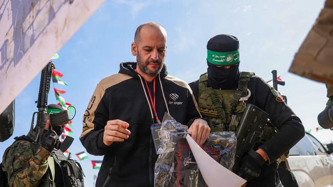 Hamas fighters escort Israeli-Argentinian hostage Yair Horn on a stage on Saturday. Picture: Bashar Taleb / AFP