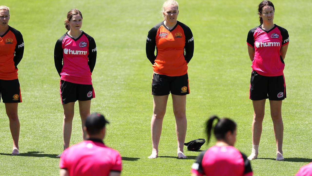 The Sixers and Scorchers WBBL players stand in a barefoot circle.