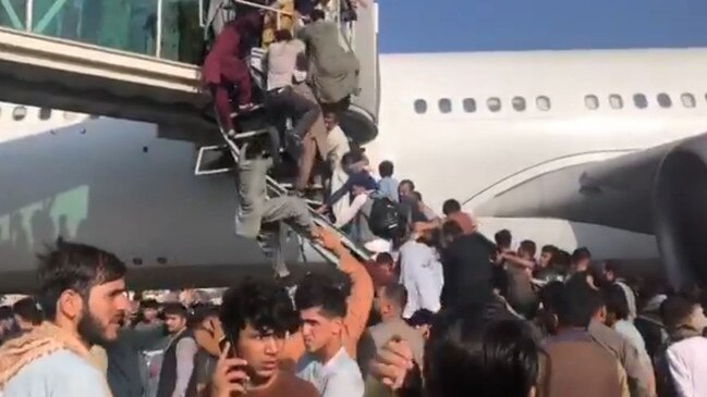 Afghans climb airport bridges, attempting to flee Kabul after the Taliban takeover. Picture: Nicola Careem