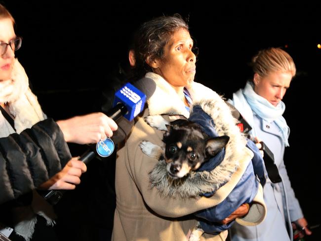 A dog is taken from the property by a family member. Picture: Stephen Laffer