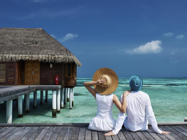 Couple on a tropical beach jetty at Maldives