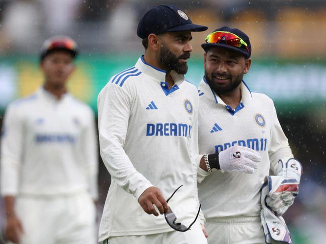 India's Virat Kohli and Rishabh Pant leave the field as the rain falls. Picture: AFP