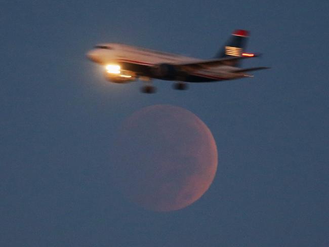 A commercial Airliner on approach to Reagan National Airport flies past the full moon during a lunar eclipse in Washington, DC. Picture: Getty/AFP