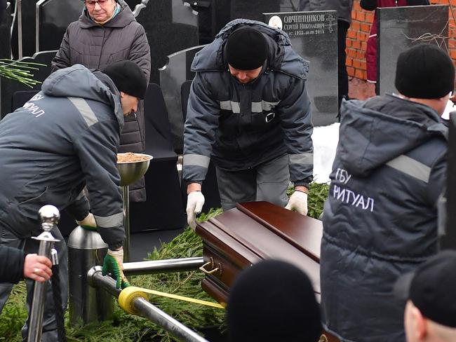 Cemetery workers lower the coffin of late Russian opposition leader Alexei Navalny. Picture: AFP