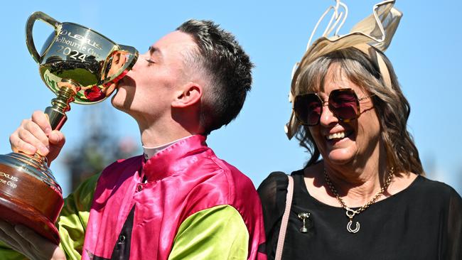 Jockey Robbie Dolan kisses the Melbourne Cup trophy as Knight’s Choice’s trainer Sheila Laxon celebrates their 2024 Melbourne Cup victory. Picture: Vince Caligiuri / Getty Images