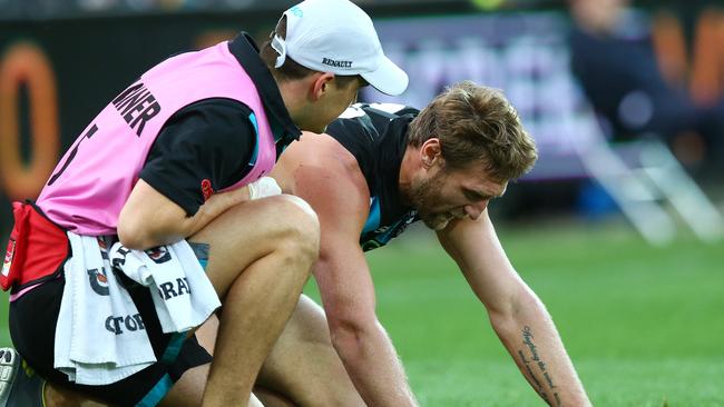 Jay Schulz is helped by trainers after getting a knee to the head. Picture: Sarah Reed