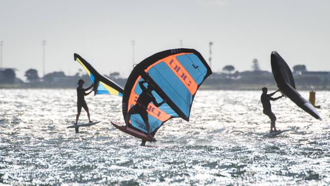 Kite surfers at Middle Park Beach are making the most of Melbourne’s warm weather. Picture: Tony Gough