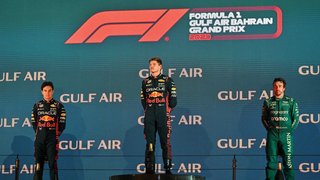 Race winner Red Bull Racing's Dutch driver Max Verstappen (C), second place winner Red Bull Racing's Mexican driver Sergio Perez (L), and third place winner Aston Martin's Spanish driver Fernando Alonso (R) attend the podium ceremony after the Bahrain Formula One Grand Prix at the Bahrain International Circuit in Sakhir on March 5, 2023. (Photo by ANDREJ ISAKOVIC / AFP)