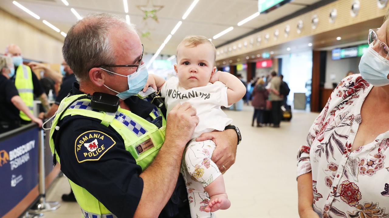 Tasmania Police Senior Constable Paul Edwards who was working at the airport on day 1 of border reopening reunited with granddaughter Isla 7 months from Newcastle who have been separated since she was 4 weeks old. Picture: Nikki Davis-Jones