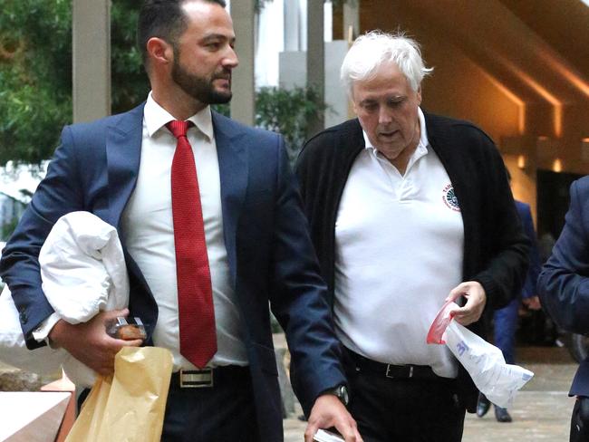 Clive Palmer and his staff arrive at court on Wednesday holding a pillow, breathing aid and sick bag.