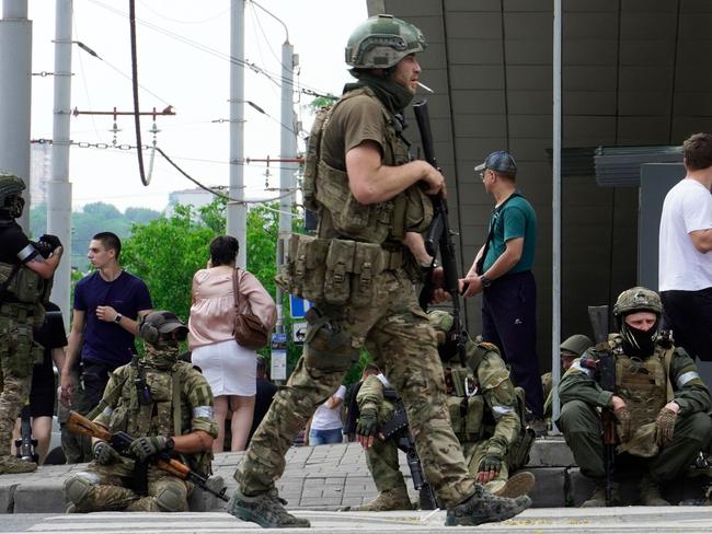 Members of Wagner Group sit on the sidewalk as they patrol the centre of Rostov-on-Don, on Saturday. Picture: AFP