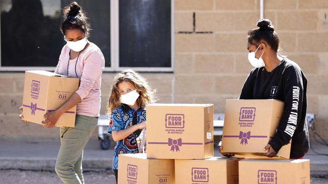 Felicia Hunter, left, Marissa Bates and Christine Hunter gather food relief parcels in Wilcannia, western NSW. Picture: Chris Pavlich