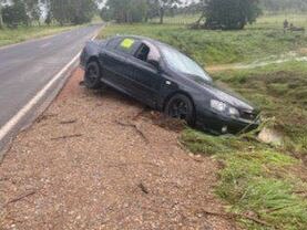 The man and the woman were pushing a black Ford Falcon in flood waters on the Burnett Highway, near Stock Yard Creek. Picture: 9 News