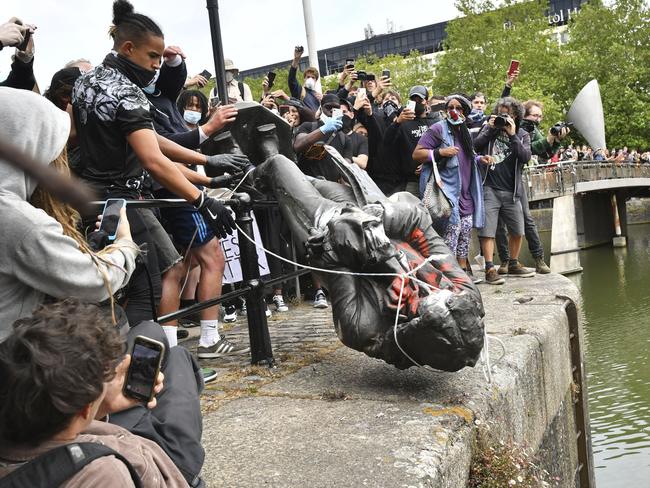 Protesters throw a statue of slave trader Edward Colston into Bristol harbour during a Black Lives Matter protest rally, in Bristol, England. Picture: AP