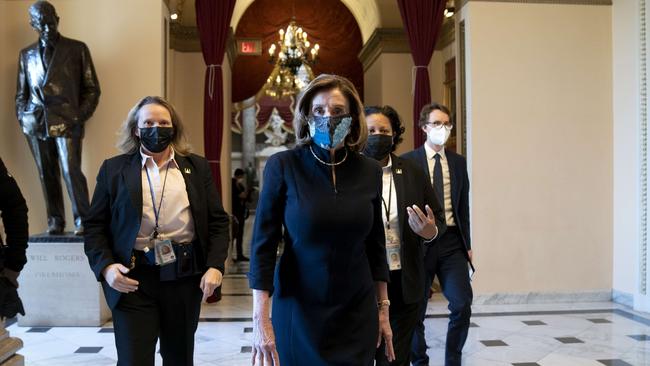 Speaker of the House Nancy Pelosi (D-CA) (C) wears a protective mask while walking to the House Floor at the U.S. Capitol on January 13. Picture: AFP