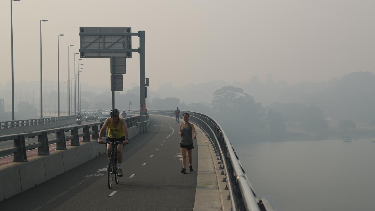 Early morning dog walkers, joggers and cyclists brave the conditions on the Drummoyne foreshore. Picture: Rohan Kelly