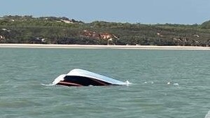 Four people have been rescued from the sea after their catamaran capsized off the Tiwi Islands.