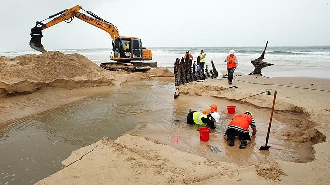 Archaeologists and council engineers work at low tide to raise the wreck of the SS Dicky.