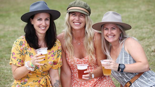 Jasmina Michetti, Ellinor Altzar and Kellie Hampton of the northern beaches relax with a cold beer in Rex Smeal Park at the Port Douglas Carnivale. Picture: Brendan Radke