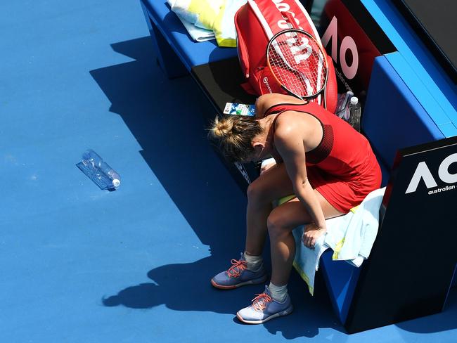 An exhausted Simona Halep remains courtside after her marathon three-setter. Picture: Getty Images