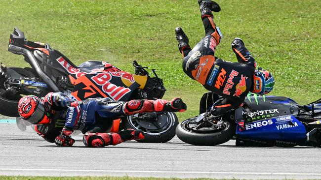 Monster Energy Yamaha MotoGP's French rider Fabio Quartararo (L) and Red Bull KTM Factory's South African rider Brad Binder (R) fall after a collision during the MotoGP Malaysian Grand Prix at the Sepang International Circuit in Sepang on November 3, 2024. (Photo by MOHD RASFAN / AFP)