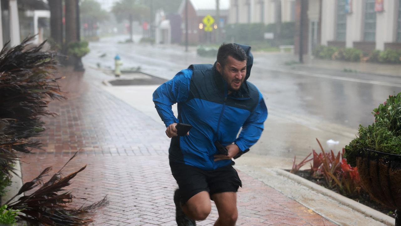 Brent Shaynore runs to a sheltered spot through the wind and rain from Hurricane Ian in Sarasota, Florida. Picture: Getty Images