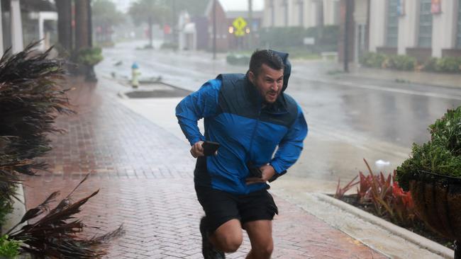 Brent Shaynore runs to a sheltered spot through the wind and rain from Hurricane Ian in Sarasota, Florida. Picture: Getty Images