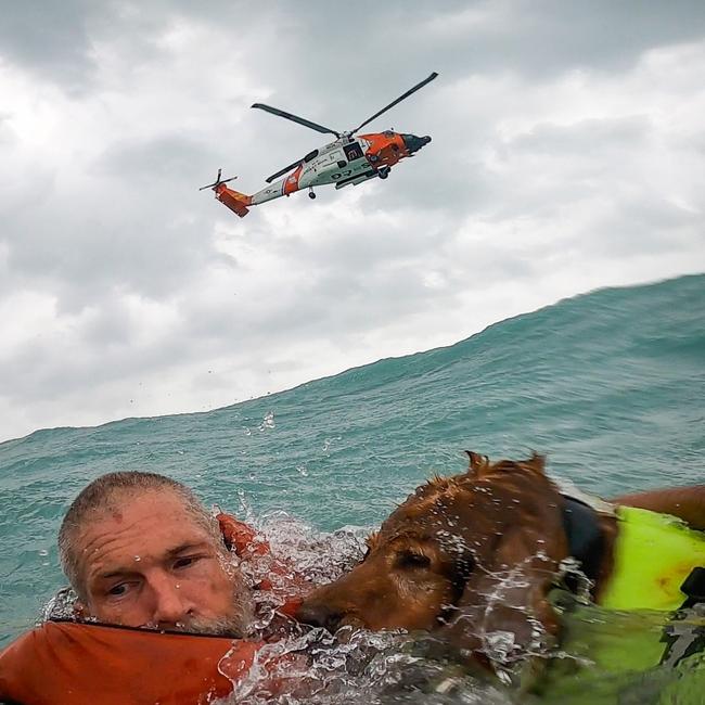 A man and his dog are rescued from off the coast of Florida by the US Coast Guard during Hurricane Helene.