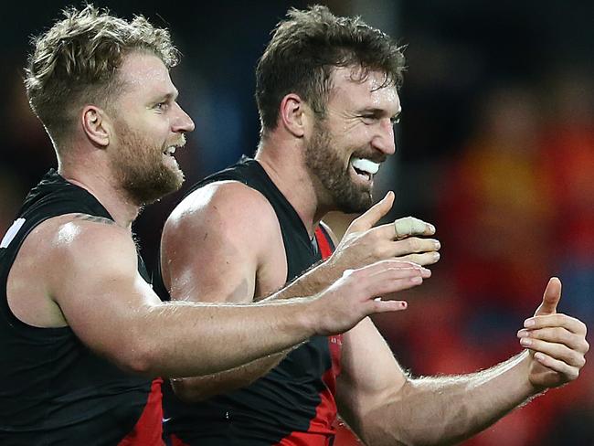 GOLD COAST, AUSTRALIA - JULY 28: Jake Stringer and Cale Hooker of the Bombers celebrate the win during the round 19 AFL match between the Gold Coast Suns and the Essendon Bombers at Metricon Stadium on July 28, 2019 in Gold Coast, Australia. (Photo by Jono Searle/AFL Photos via Getty Images)