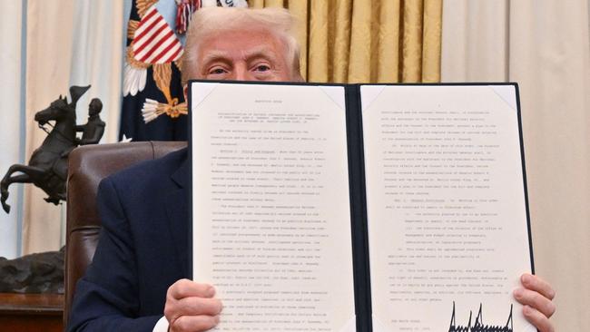 Donald Trump holds the executive order he signed to declassify the files of assassinated former President John F. Kennedy, former Attorney-General Robert F. Kennedy and civil rights leader Martin Luther King Jr. Picture: AFP.