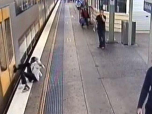 The man stumbles after kicking out of the train.