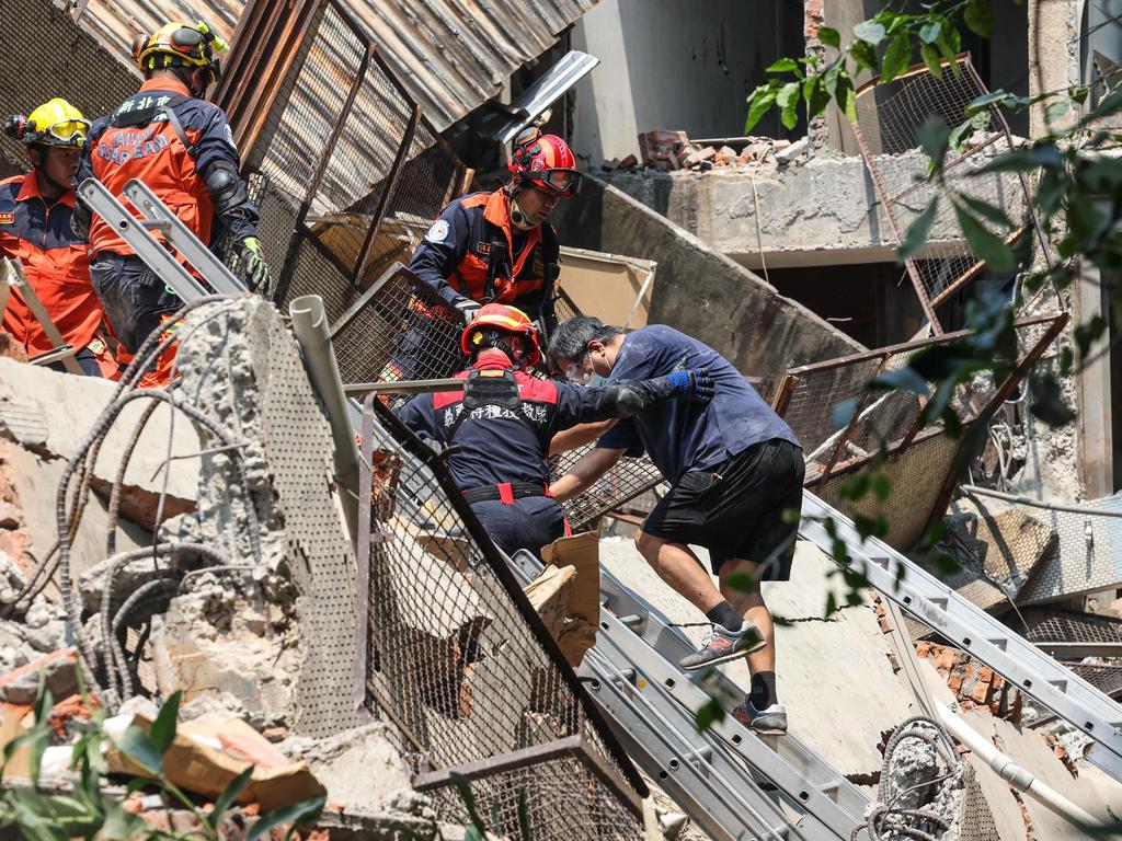 Emergency workers assisting a survivor after he was rescued from a damaged building in New Taipei City. Picture: CNA/AFP