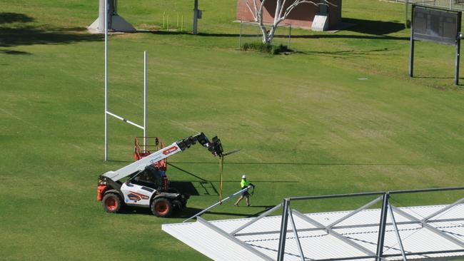 Workers dismantling the Anzac Oval goalposts.