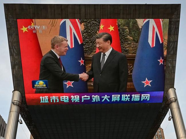 An outdoor screen shows news coverage of New Zealand's Prime Minister Chris Hipkins meeting with China's President Xi Jinping at the Great Hall of the People, along a street in Beijing on June 27, 2023. (Photo by Jade Gao / AFP)