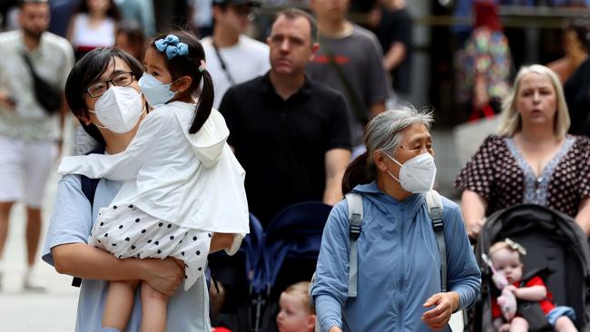 A family wearing masks in Queen Street Mall in Brisbane’s CBD. Picture: David Clark