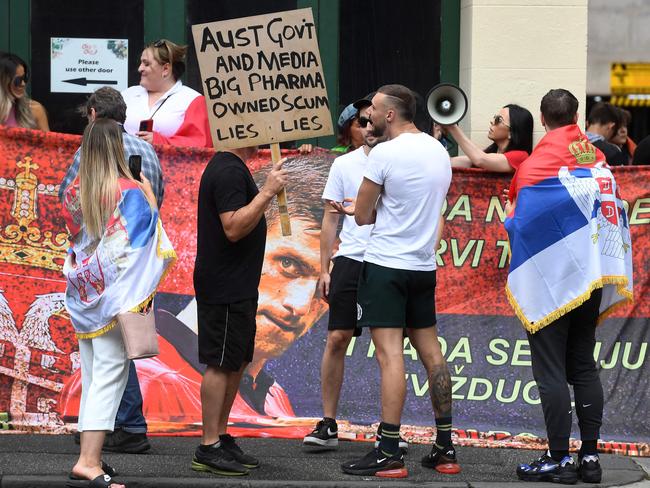 People hold placards up at a hotel on Friday where Djokovic is detained. Picture: William West / AFP