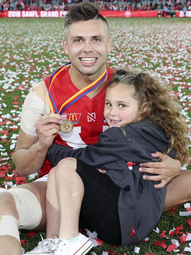 Robbie Young with his daughter Nayari after North’s SANFL grand final win. Young was selected by Saint Kilda at the AFL national draft on Friday. Picture: Sarah Reed