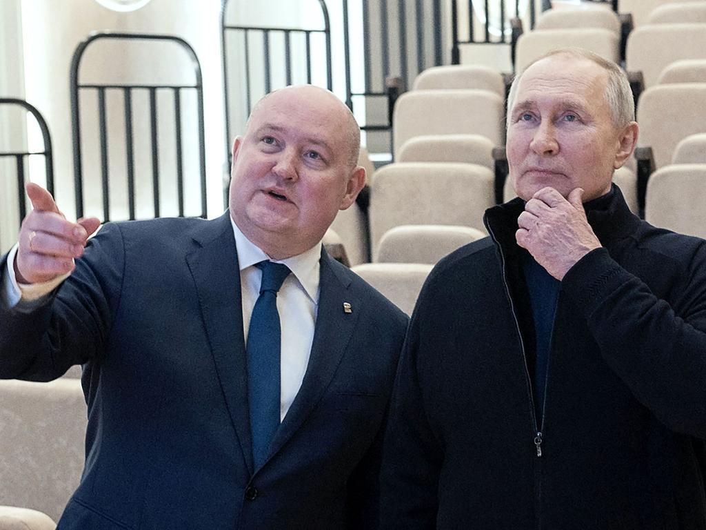 Russian President Vladimir Putin listening to Sevastopol Governor Mikhail Razvozhayev (L) as he visits a children's arts-and-crafts centre in Sevastopol. Picture: AFP